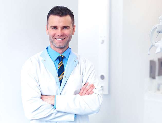 Homem odontologista em pé na clínica odontológica e esperando o próximo paciente. 