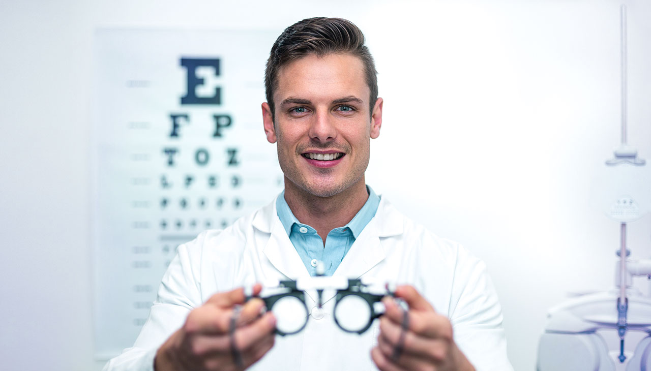 Opticien die een bril geeft (mess brille) tijdens oogtest.