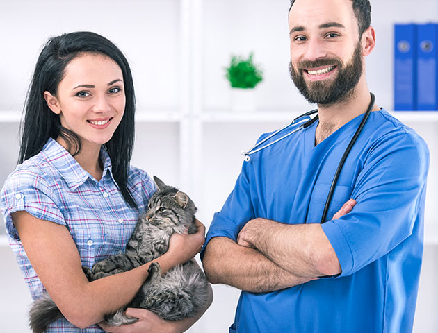 Veterinar in lastnik hišnih ljubljenčkov pozirata po sestanku pri veterinarju.